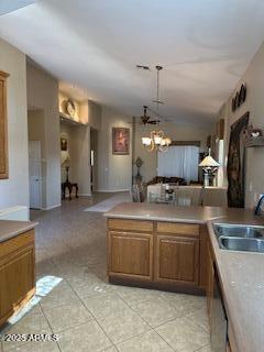 kitchen featuring light countertops, a chandelier, brown cabinets, and decorative light fixtures