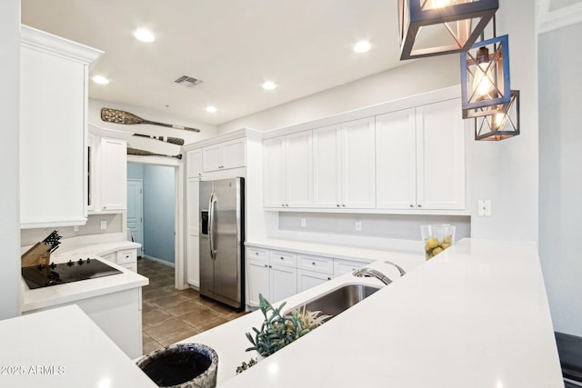 kitchen with stainless steel refrigerator with ice dispenser, black electric stovetop, white cabinetry, and recessed lighting