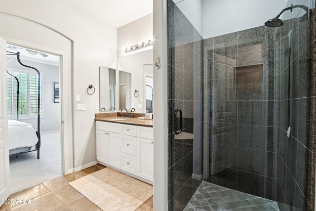 bathroom with tiled shower, tile patterned floors, vanity, and ensuite bathroom
