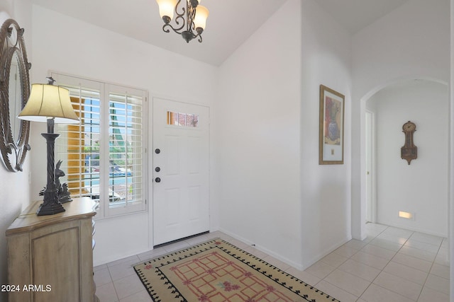 foyer featuring lofted ceiling, a chandelier, and light tile patterned floors