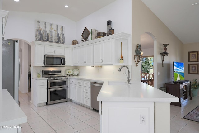 kitchen featuring kitchen peninsula, white cabinets, high vaulted ceiling, sink, and stainless steel appliances