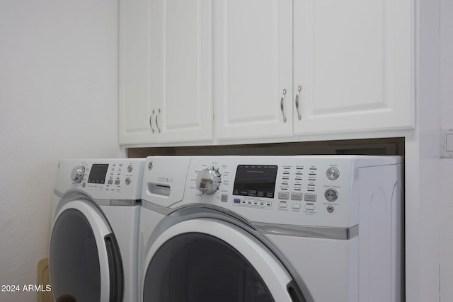 laundry area with washer and dryer and cabinets