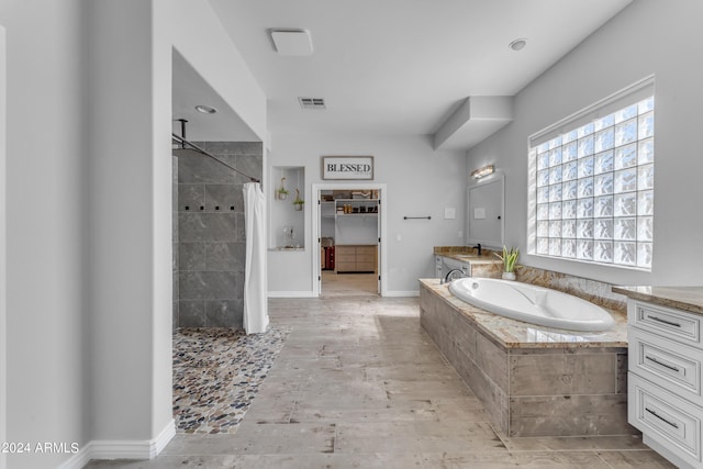 bathroom featuring vanity and shower with separate bathtub