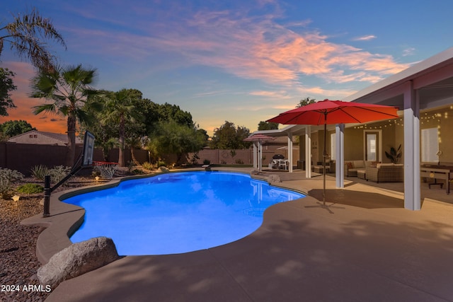 pool at dusk featuring an outdoor hangout area and a patio area