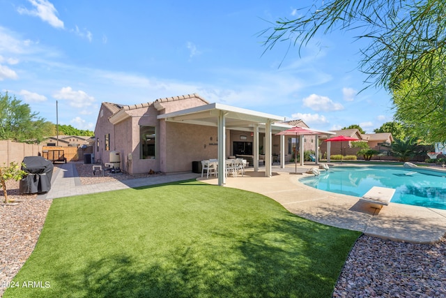 exterior space with a grill, a diving board, a yard, and a patio area