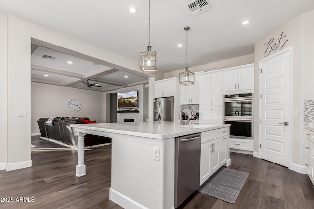 kitchen featuring a center island with sink, white cabinets, sink, beam ceiling, and stainless steel appliances