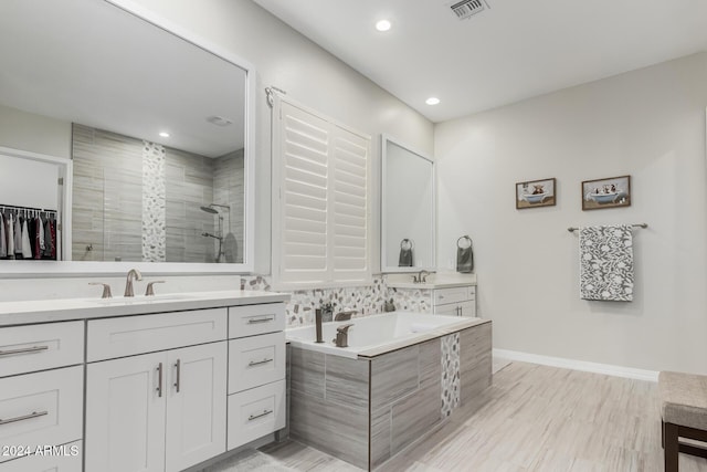 bathroom with vanity, wood-type flooring, and shower with separate bathtub