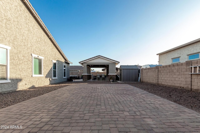 view of patio featuring a gazebo and a storage shed