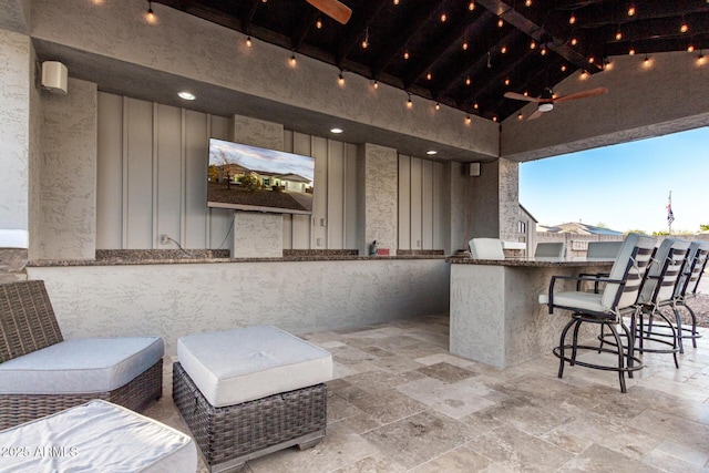 view of patio with area for grilling, ceiling fan, and an outdoor bar