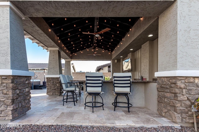 view of patio / terrace featuring ceiling fan and a bar