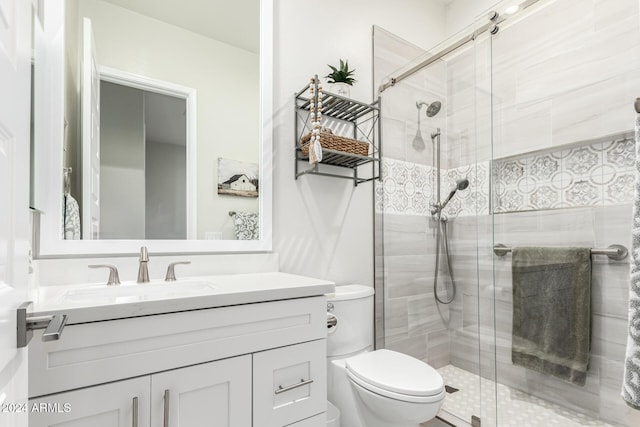 bathroom with vanity, toilet, and a shower with door