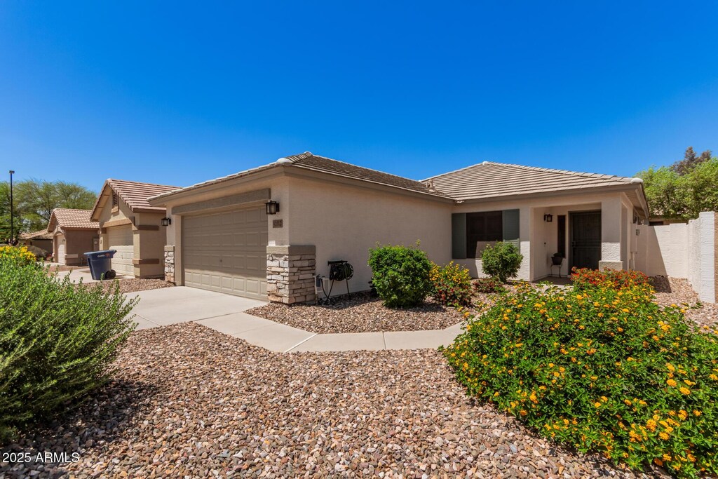 4262 E Sundance Ave, Gilbert, AZ 85297 - view of front of home featuring a garage, stone siding, stucco siding, a tiled roof, and driveway