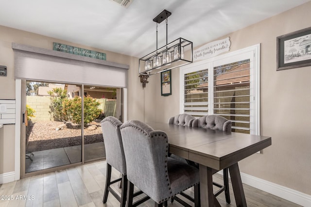 4262 E Sundance Ave, Gilbert, AZ 85297 - dining space with baseboards, light wood-type flooring, and a chandelier