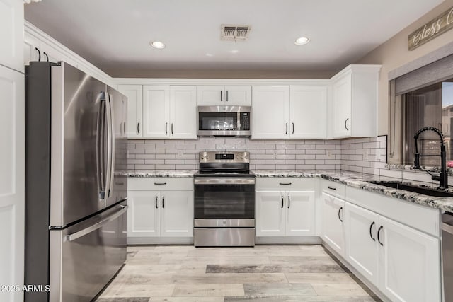 4262 E Sundance Ave, Gilbert, AZ 85297 - kitchen with visible vents, white cabinetry, light stone counters, a sink, and stainless steel appliances