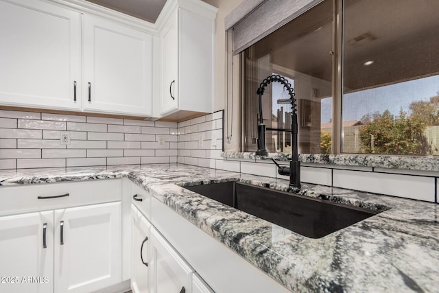 4262 E Sundance Ave, Gilbert, AZ 85297 - kitchen featuring a sink, light stone counters, white cabinets, and backsplash
