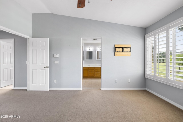 3025 E Fremont Rd, Phoenix, AZ 85042 - unfurnished bedroom featuring light colored carpet, vaulted ceiling, ensuite bathroom, and a ceiling fan