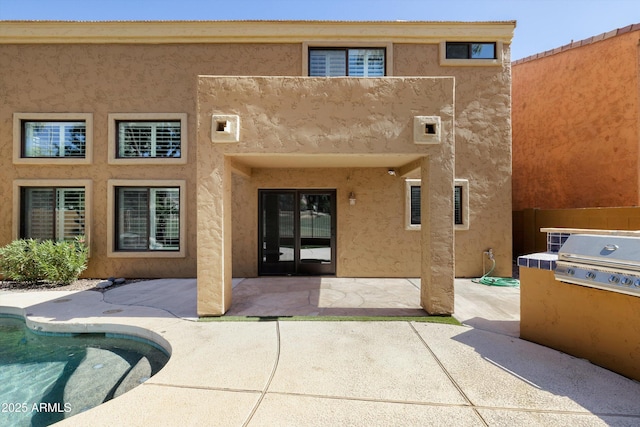 3025 E Fremont Rd, Phoenix, AZ 85042 - rear view of house featuring stucco siding, a patio, and an outdoor pool