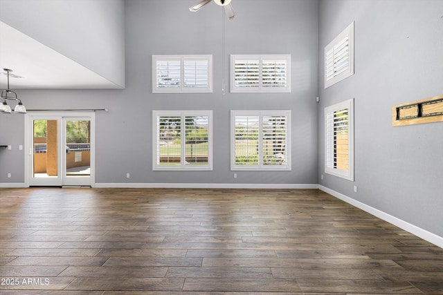 3025 E Fremont Rd, Phoenix, AZ 85042 - unfurnished living room with a ceiling fan, dark wood-style floors, a high ceiling, and a chandelier