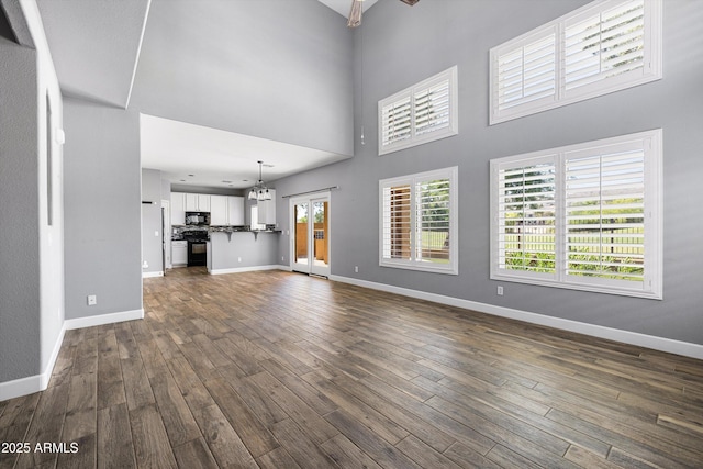 3025 E Fremont Rd, Phoenix, AZ 85042 - unfurnished living room featuring a high ceiling, dark wood-style floors, and a chandelier