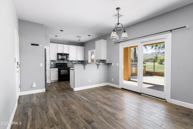 3025 E Fremont Rd, Phoenix, AZ 85042 - kitchen with black appliances, white cabinets, a kitchen bar, and plenty of natural light