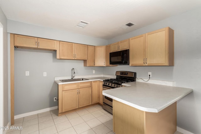 kitchen with kitchen peninsula, light brown cabinetry, stainless steel gas range, sink, and light tile patterned floors