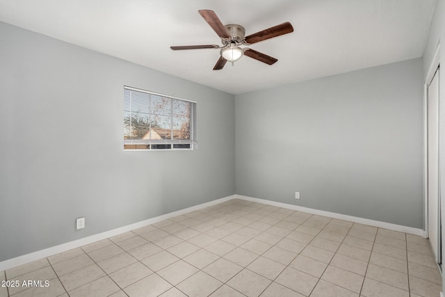 tiled spare room featuring ceiling fan