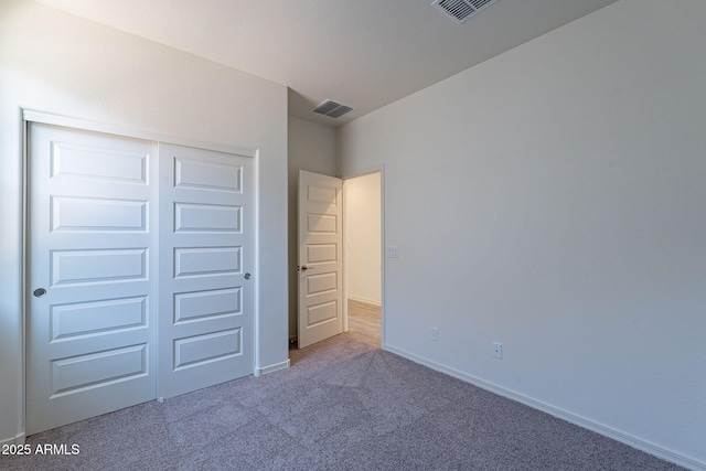 unfurnished bedroom with a closet and carpet flooring