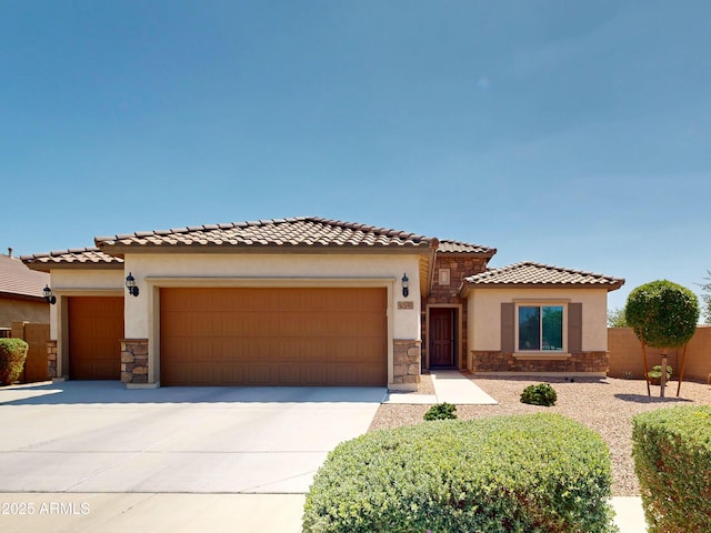 17547 W Gambit Trl, Surprise, AZ 85387 - mediterranean / spanish house featuring stone siding, a garage, concrete driveway, and stucco siding