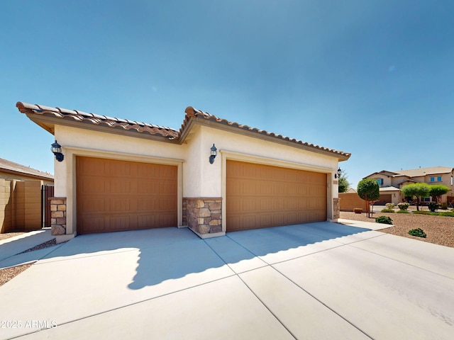 17547 W Gambit Trl, Surprise, AZ 85387 - mediterranean / spanish home with stone siding, stucco siding, a garage, concrete driveway, and a tiled roof