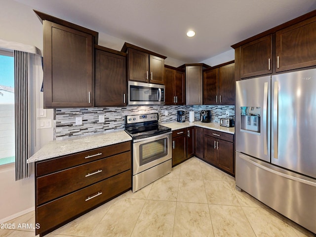 17547 W Gambit Trl, Surprise, AZ 85387 - kitchen featuring appliances with stainless steel finishes, tasteful backsplash, dark brown cabinets, light tile patterned flooring, and recessed lighting