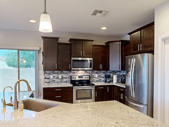 17547 W Gambit Trl, Surprise, AZ 85387 - kitchen featuring appliances with stainless steel finishes, a sink, decorative backsplash, dark brown cabinets, and recessed lighting