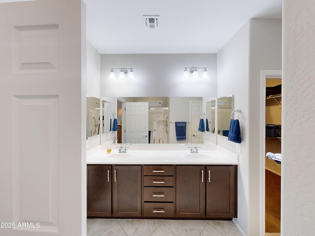 17547 W Gambit Trl, Surprise, AZ 85387 - full bath with double vanity, a shower stall, a walk in closet, and tile patterned floors