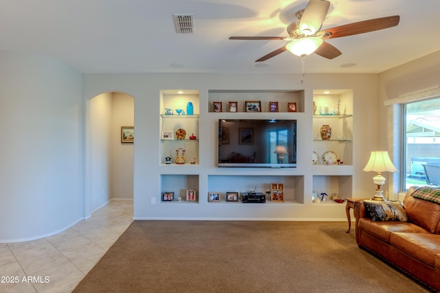 17547 W Gambit Trl, Surprise, AZ 85387 - tiled living area with built in shelves, arched walkways, a ceiling fan, and baseboards