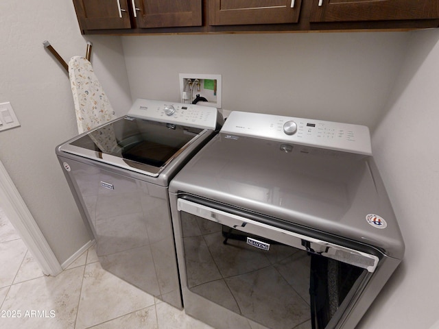 17547 W Gambit Trl, Surprise, AZ 85387 - laundry area featuring separate washer and dryer, cabinet space, light tile patterned floors, and baseboards