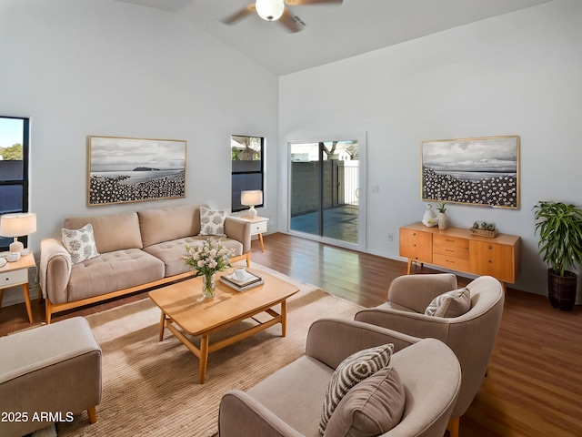 living room with ceiling fan, wood-type flooring, and vaulted ceiling