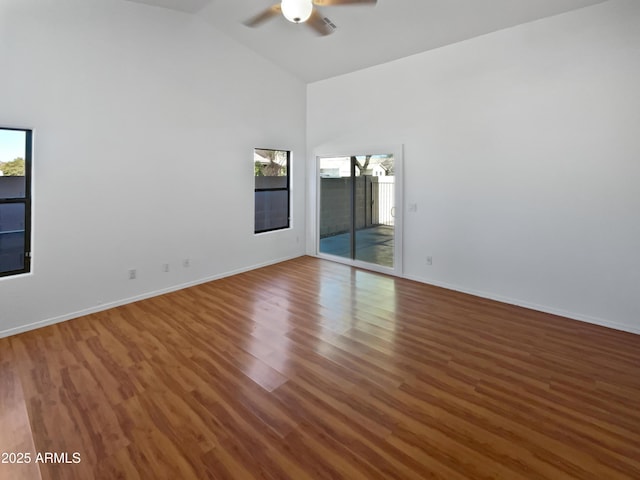 empty room with ceiling fan, high vaulted ceiling, and hardwood / wood-style floors