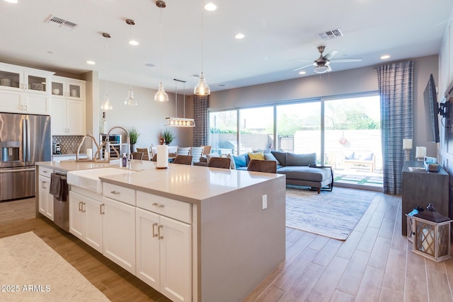 kitchen featuring light wood-type flooring, visible vents, appliances with stainless steel finishes, and a sink