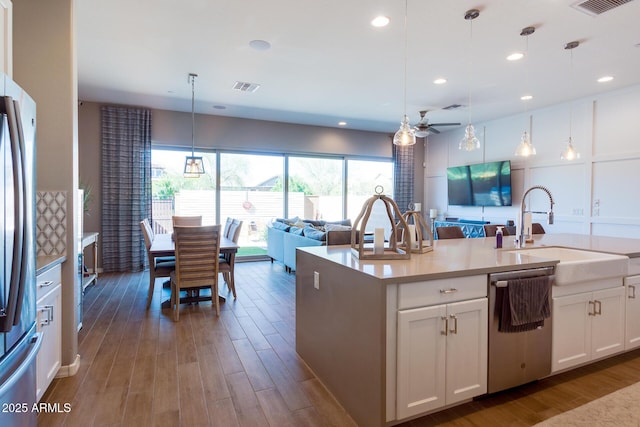 kitchen with visible vents, appliances with stainless steel finishes, open floor plan, dark wood-style flooring, and a sink