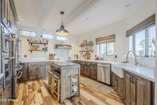 kitchen featuring light wood-style flooring, beam ceiling, stainless steel dishwasher, open shelves, and a sink