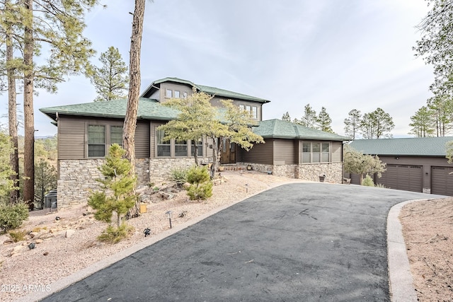 view of front of property with a shingled roof and stone siding