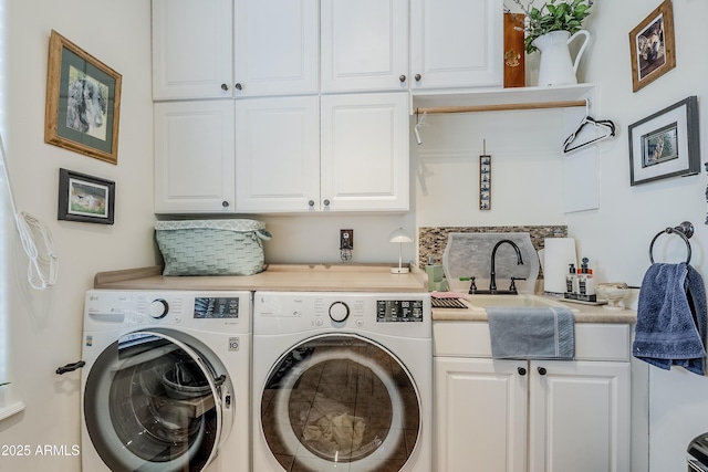 washroom with washing machine and dryer, cabinet space, and a sink