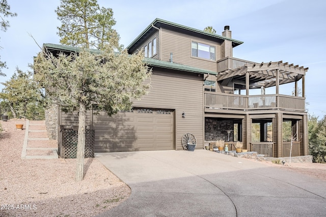 view of front of home featuring a garage, concrete driveway, and a pergola