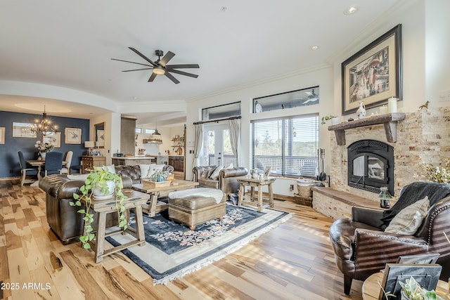 living area with light wood-style floors, baseboards, crown molding, and a glass covered fireplace