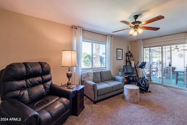 carpeted living room with a textured ceiling and ceiling fan