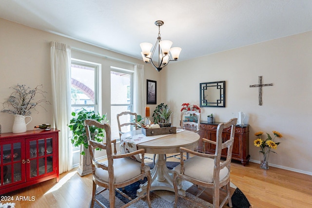 dining space with light wood-type flooring and a chandelier