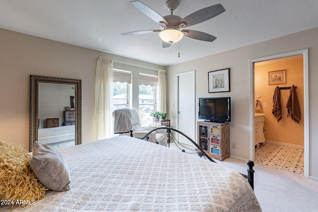 carpeted bedroom with ceiling fan and ensuite bath