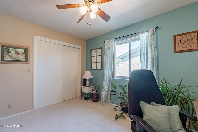 carpeted home office featuring ceiling fan