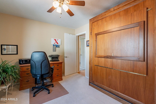 carpeted office with a textured ceiling and ceiling fan