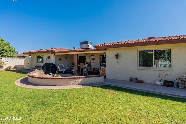 rear view of property with a lawn, cooling unit, and a patio