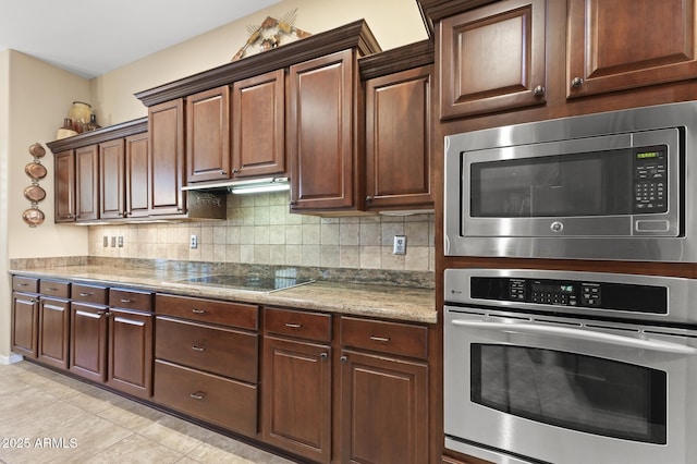 kitchen featuring tasteful backsplash, light tile patterned floors, and stainless steel appliances